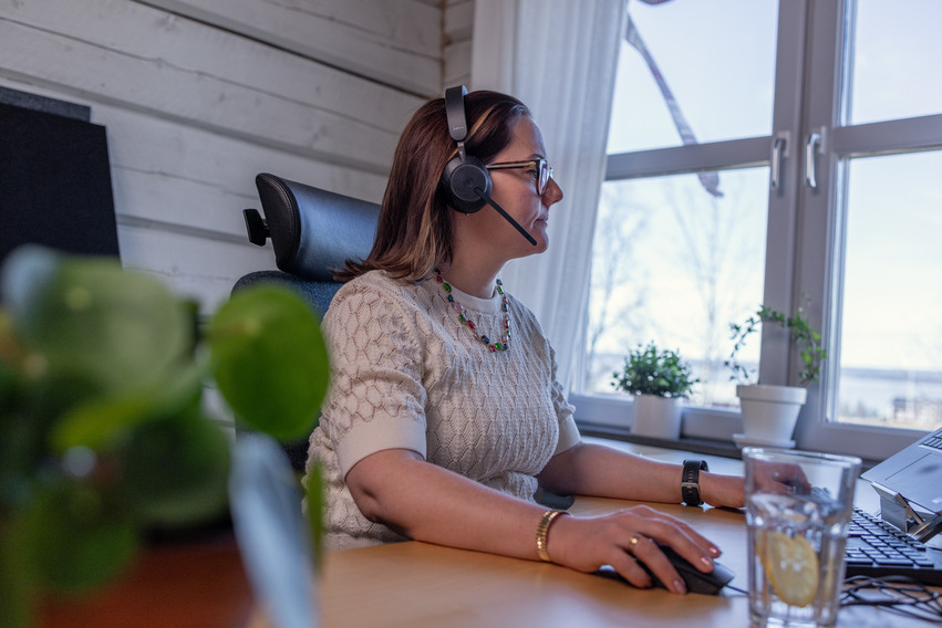 Person som sitter vid ett skrivbord och pratar i telefon