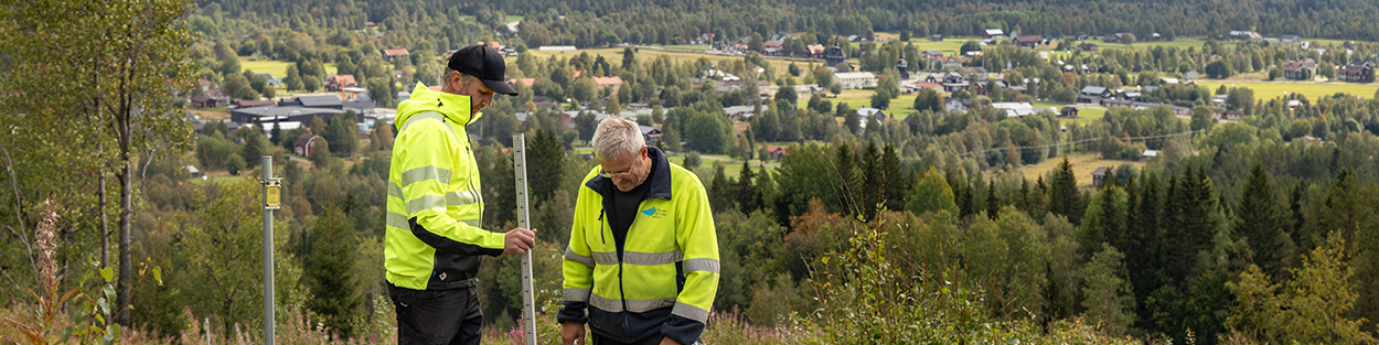 Två personer med varselkläder i utomhusmiljö