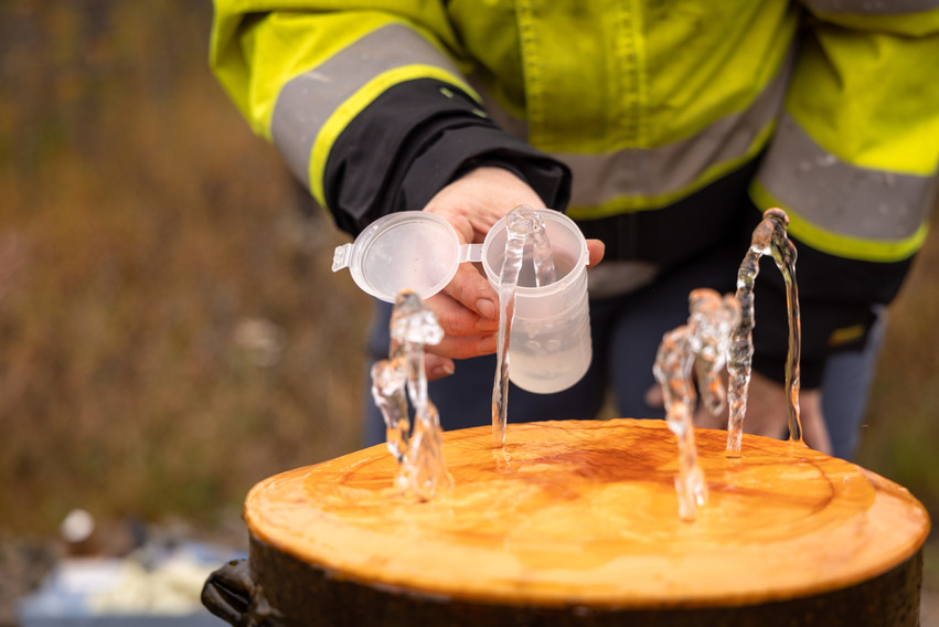 Händer som visar vattenprovtagning