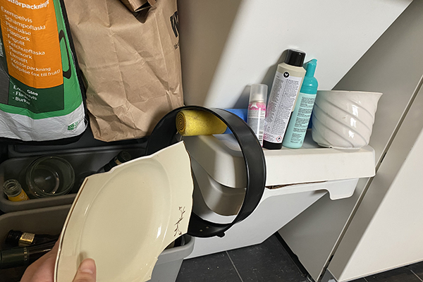 Sortering hemma med vanligt skräp som glasförpackningar, gamla leksaker, hårspray, krukor